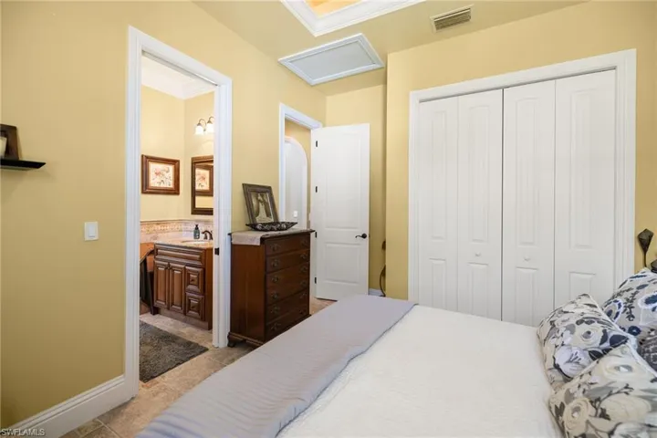 Bedroom with a closet, crown molding, and connected bathroom