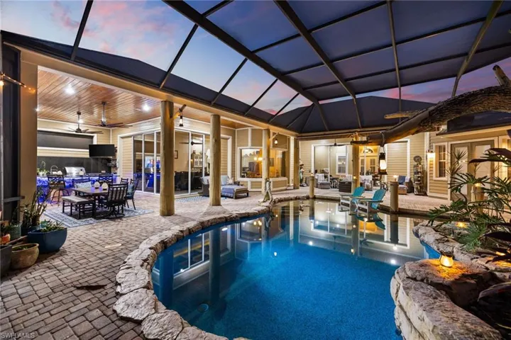 Swimming pool with an outdoor living / dining area, a sunroom, a patio area, and a lanai
