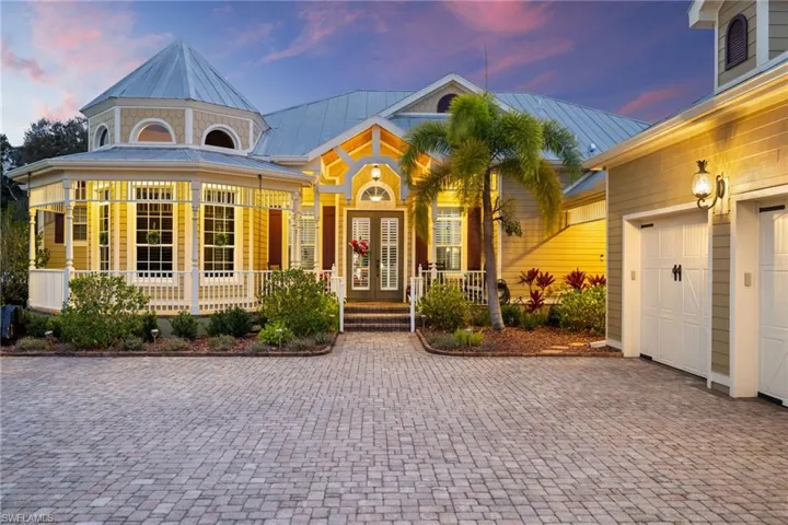 View of front of home featuring a porch, a garage, decorative driveway, and a metal roof