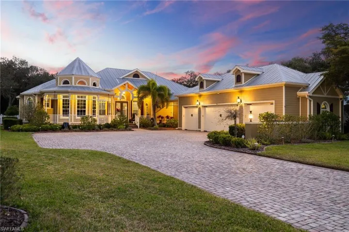 View of front of home featuring a lawn, decorative driveway, and a metal roof