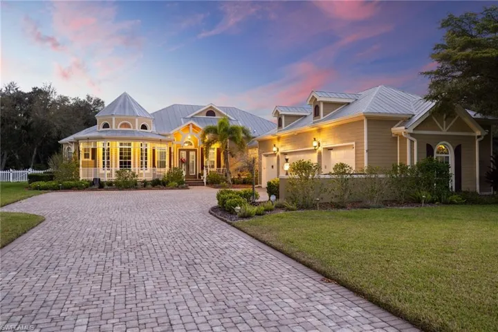 View of front of property featuring a porch, a front yard, decorative driveway, and a garage