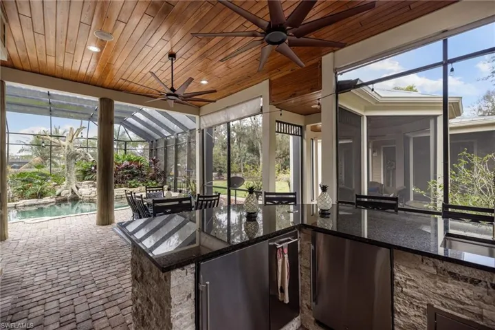 Unfurnished sunroom featuring area for grilling, a ceiling fan, and healthy amount of natural light