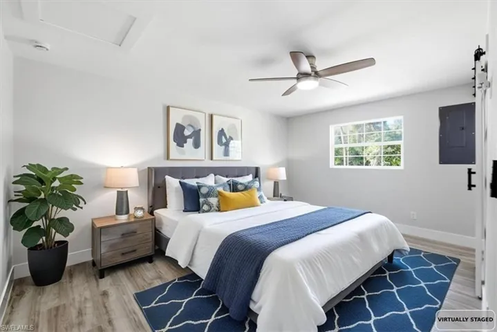 Bedroom 2 with electric panel, light wood finished floors, and a ceiling fan virtually staged
