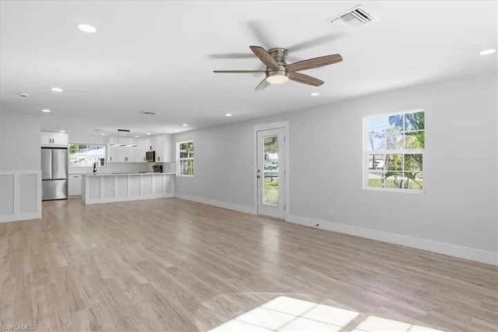 Unfurnished living room featuring light wood-style flooring, a ceiling fan, and recessed lighting