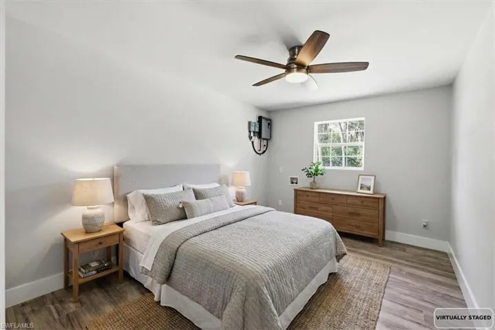 Bedroom 3 with wood finished floors and ceiling fan virtually Staged