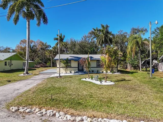 View of front of house featuring a front lawn, driveway, and stucco siding