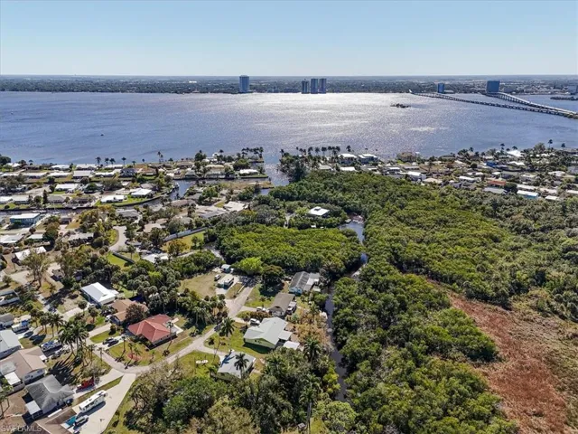 Aerial perspective of suburban area with a large body of water and a notable bridge