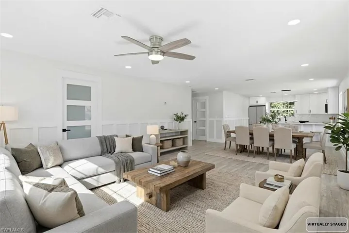 Living room with light wood-type flooring, -ceiling fan, a decorative wall, recessed lighting, and a wainscoted wall Virtualy stage