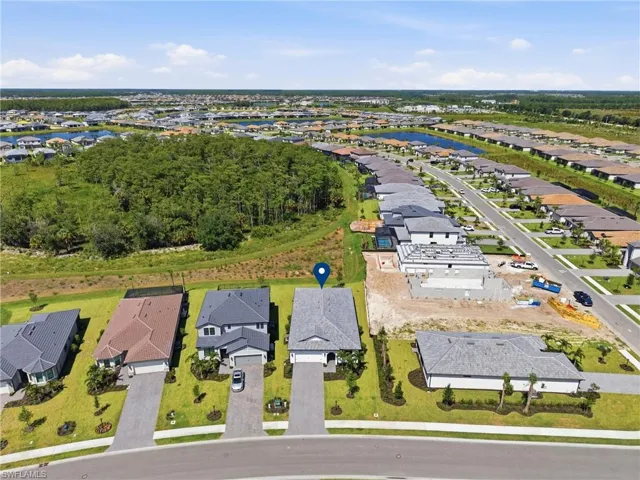 Expansive community with a tree-lined perimeter, paved streets, and uniform residential architecture