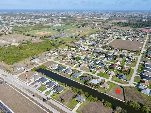 Aerial overview of property's location featuring a nearby body of water and nearby suburban area