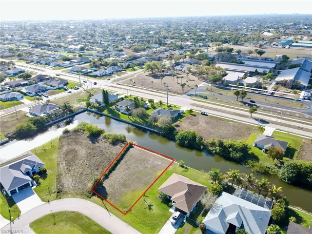 Aerial perspective of suburban area with property boundaries highlighted and a nearby body of water