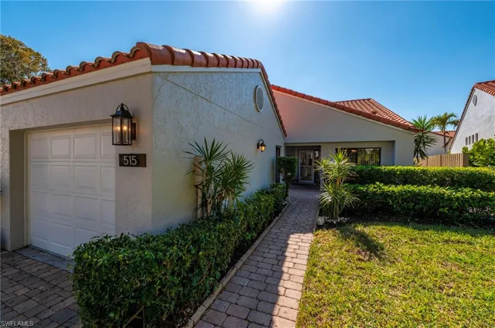 View of front of home with a tile roof, stucco siding, and a garage