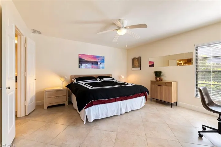 Bedroom with a ceiling fan and light tile patterned floors