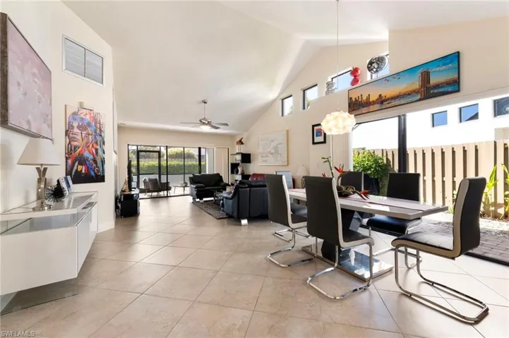 Dining area featuring a high ceiling, ceiling fan, and light tile patterned floors