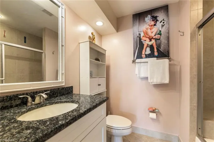 Bathroom featuring a stall shower, vanity, and light tile patterned floors