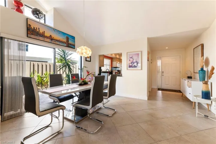 Dining space featuring lofted ceiling and light tile patterned floors