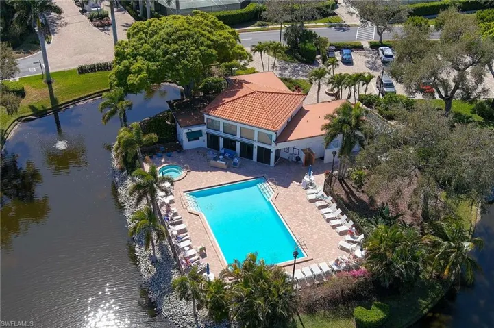 Drone / aerial view of a nearby body of water and a pool