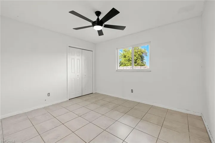 Spare room with ceiling fan and light tile patterned floors