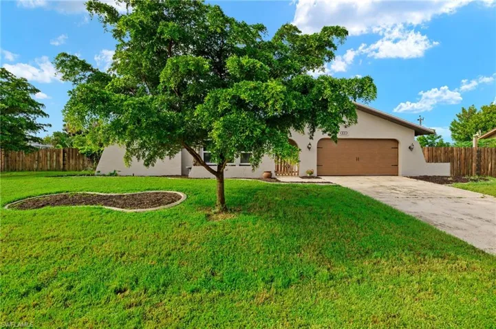View of front of property featuring a garage and a front yard