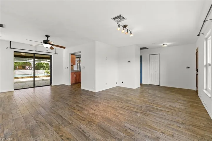 Unfurnished room featuring rail lighting, hardwood / wood-style flooring, and ceiling fan