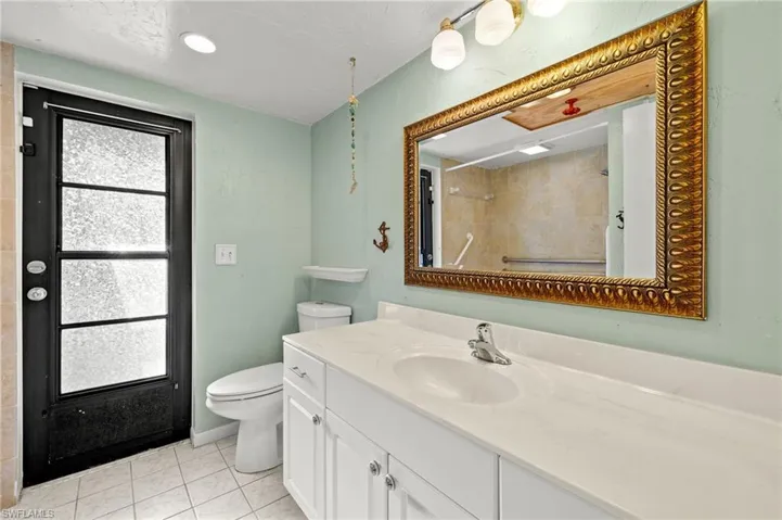 Bathroom featuring tile patterned flooring, toilet, and vanity