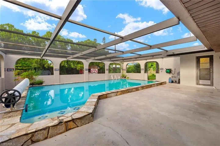 View of pool with a patio and a lanai