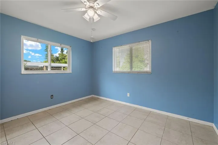Spare room with light tile patterned floors and ceiling fan