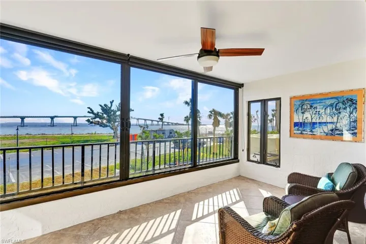 Sunroom / solarium featuring a water view and ceiling fan