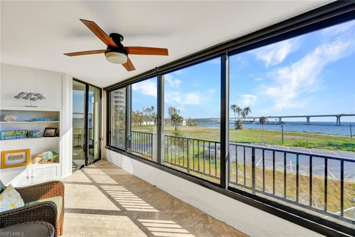 Sunroom featuring a water view and ceiling fan