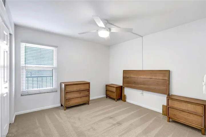 Living area featuring light colored carpet and ceiling fan