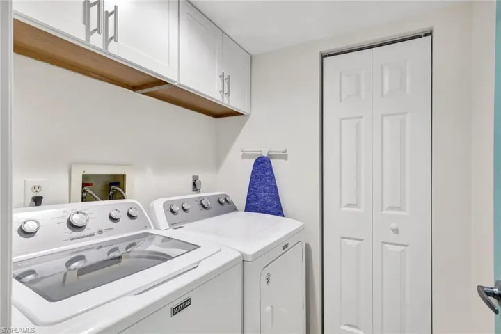 Laundry room with washer and clothes dryer and cabinets