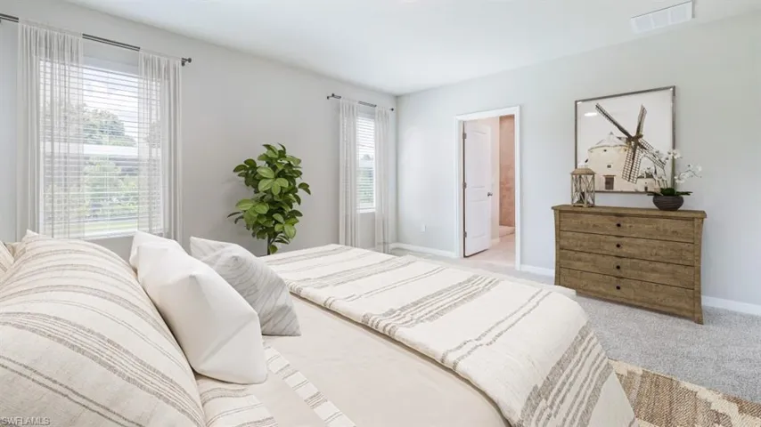 Bedroom featuring light colored carpet, visible vents, and baseboards