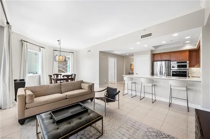 Living area featuring crown molding, light tile patterned flooring, and recessed lighting
