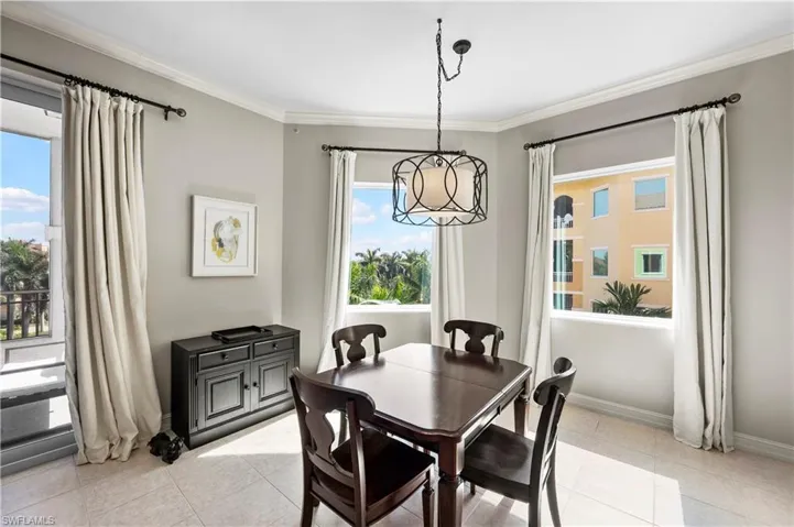Dining area featuring ornamental molding and light tile patterned floors