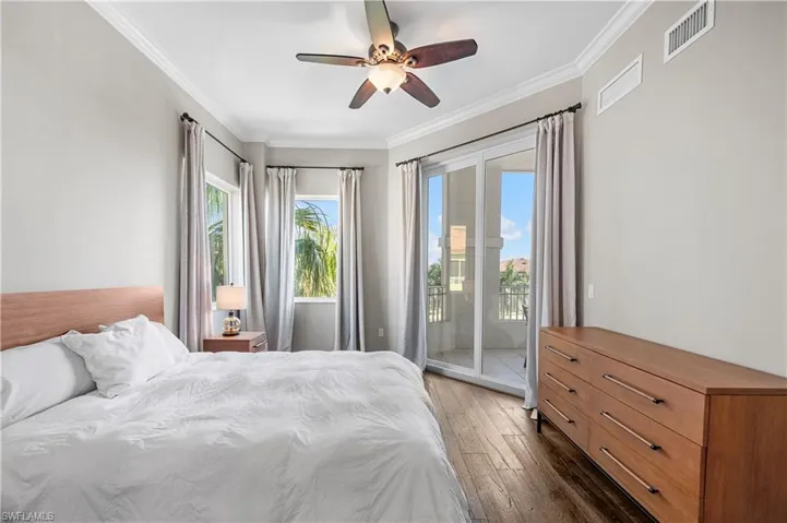 Bedroom featuring access to outside, wood finished floors, ornamental molding, and a ceiling fan