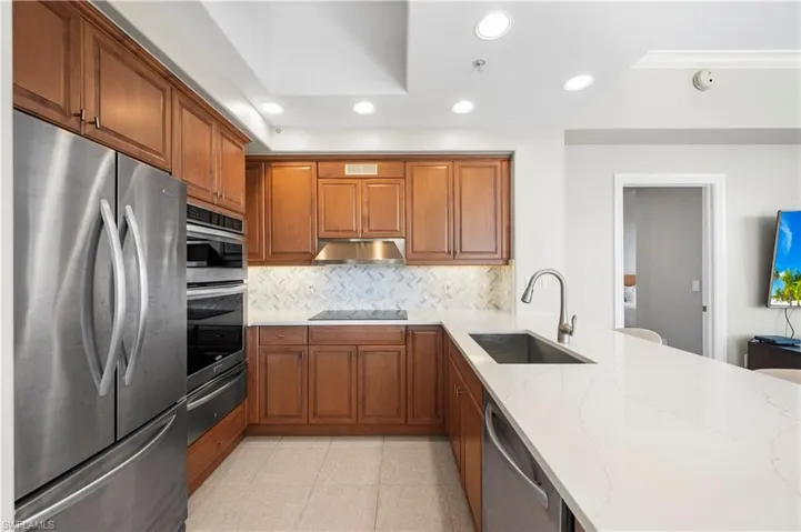 Kitchen with stainless steel appliances, a warming drawer, brown cabinetry, tasteful backsplash, and recessed lighting
