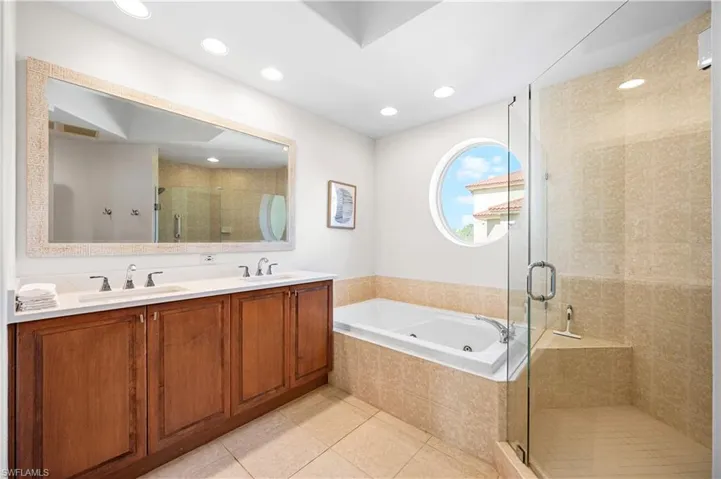 Full bath with a shower stall, a tub with jets, tile patterned flooring, double vanity, and recessed lighting