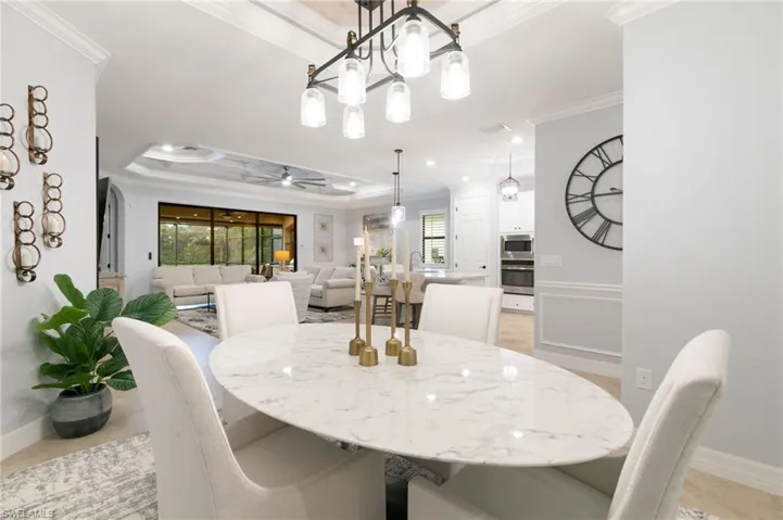 Dining space featuring crown molding, a raised ceiling, and ceiling fan