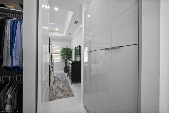 Bathroom featuring tile floors, ornamental molding, and a raised ceiling