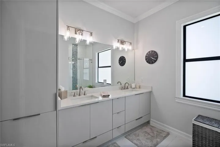 Bathroom featuring tile floors, ornamental molding, and double vanity