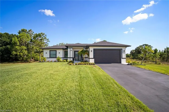 View of front of house featuring a garage and a front yard