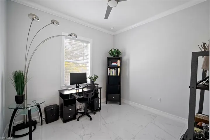 Office featuring ceiling fan, light tile flooring, and ornamental molding