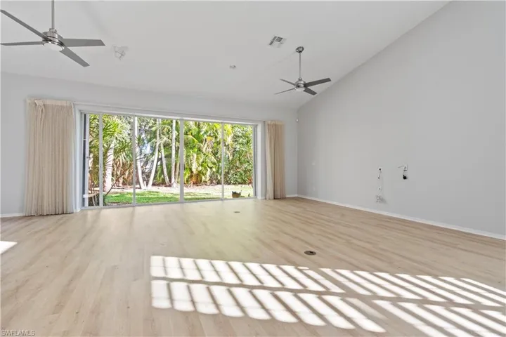 Unfurnished living room with a ceiling fan, light wood-type flooring, and high vaulted ceiling