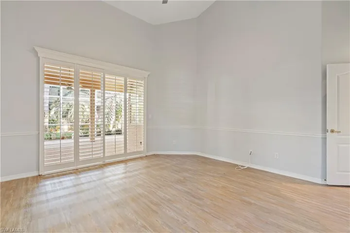 Empty room with a high ceiling and light wood-style flooring