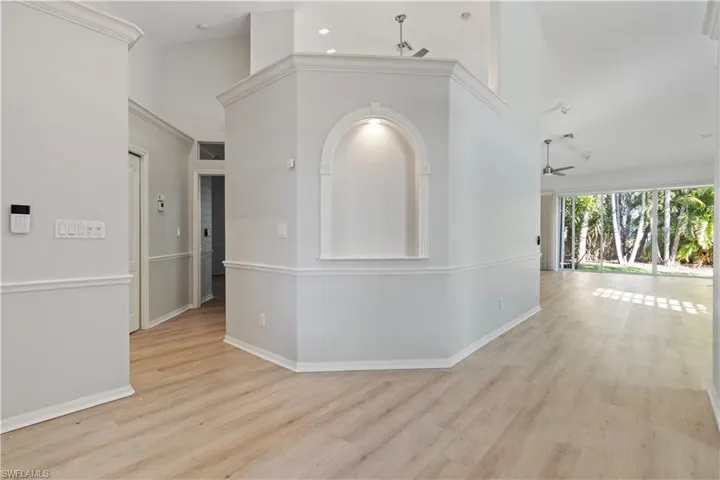 Hall featuring light wood-style flooring and a high ceiling