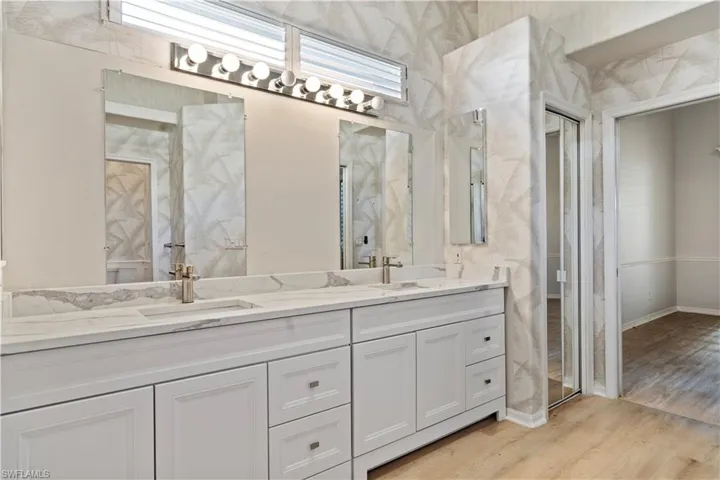 Bathroom featuring double vanity and light wood-type flooring