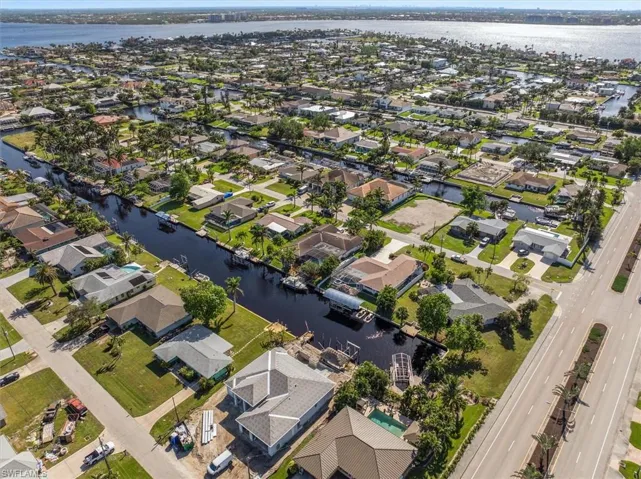 Aerial view of property and surrounding area featuring nearby suburban area