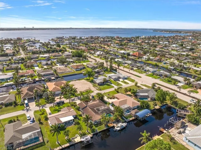 Aerial perspective of suburban area featuring a nearby body of water