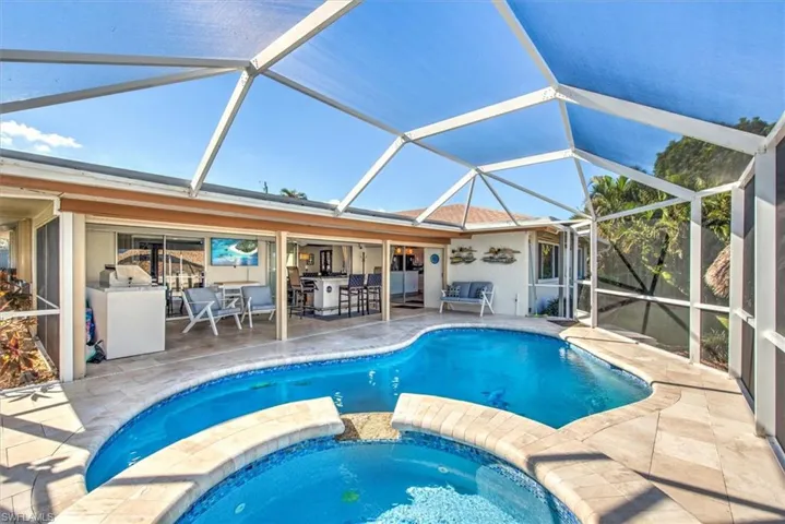 View of pool with a sunroom, a patio, a pool with connected hot tub, and a lanai