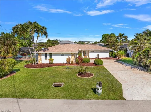 Ranch-style house featuring driveway, a front yard, roof with shingles, and stucco siding
